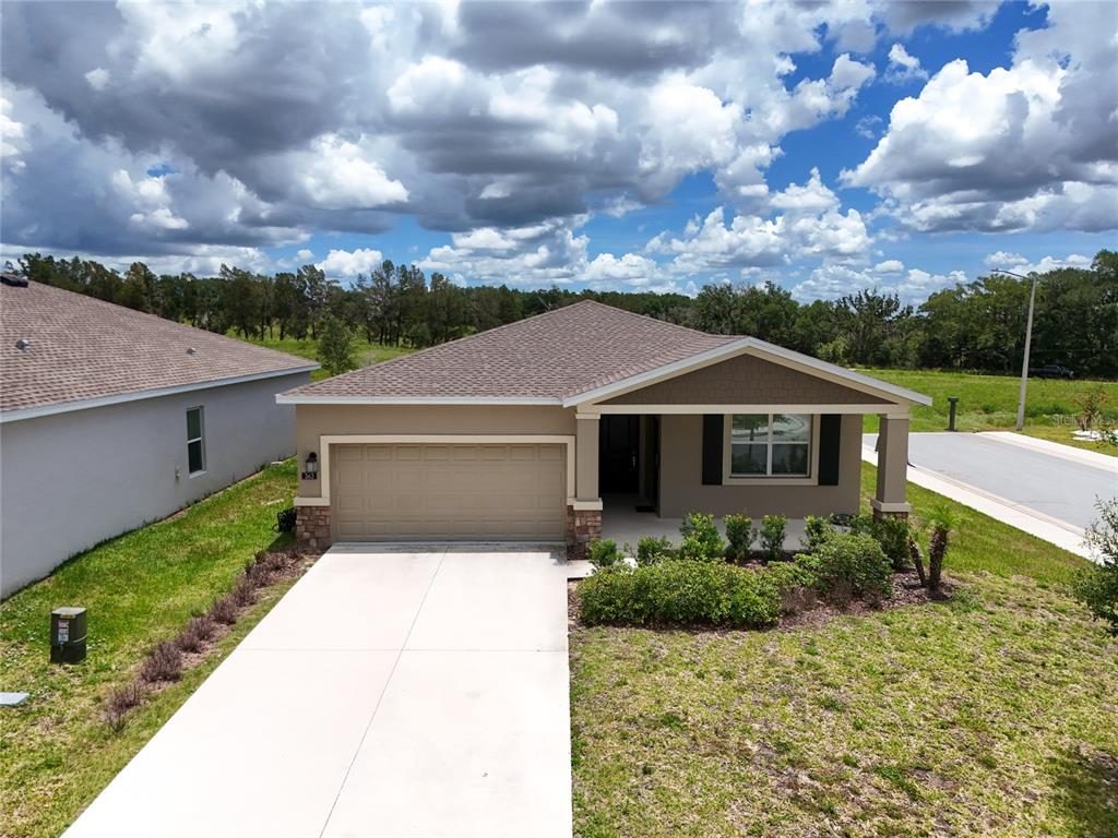 An aerial view of a single-story suburban house with a concrete driveway and garage — 363 LOCH COURT, DAVENPORT, FL