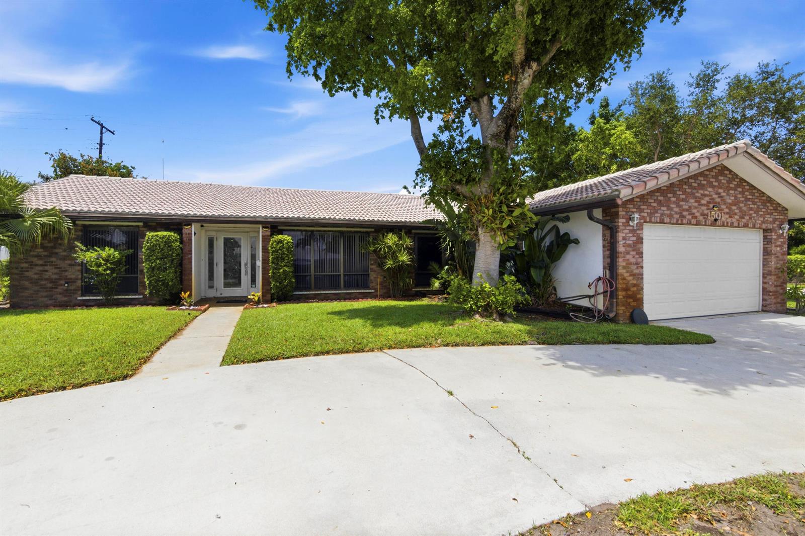 A single-story brick house with a tiled roof, a two-car garage, and a front lawn — 1501 NW 7th Street, Boca Raton FL 33486, BOCA RATON, FL