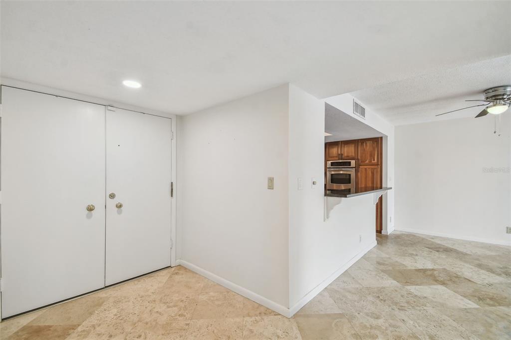 An entryway with white double doors leads to a kitchen with wood cabinets and tile flooring — 100 OAKMONT LANE UNIT 106, BELLEAIR, FL