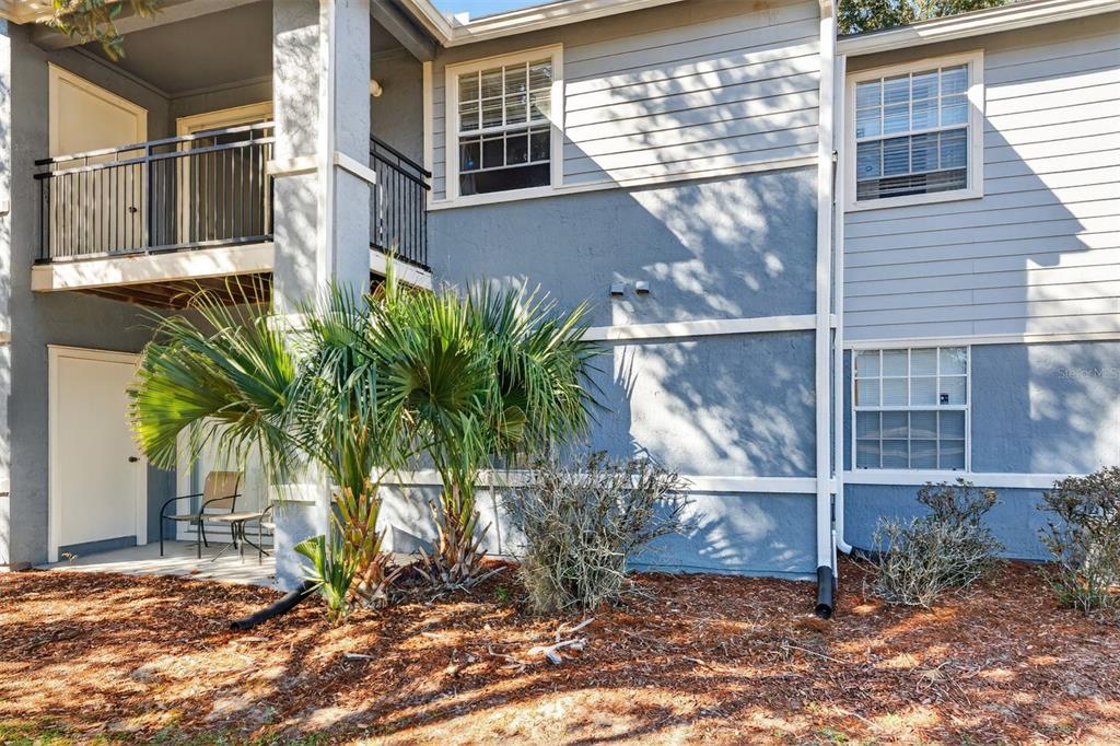 The exterior of a two-story apartment building features blue siding, a balcony, and a patio — 3705 SW 27TH STREET UNIT 326, GAINESVILLE, FL