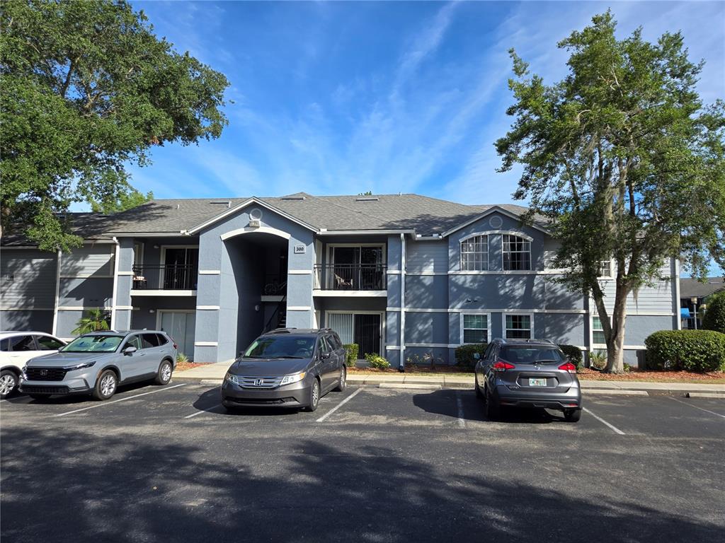 A two-story apartment building with gray siding and a parking lot in front — 3705 SW 27TH STREET UNIT 326, GAINESVILLE, FL