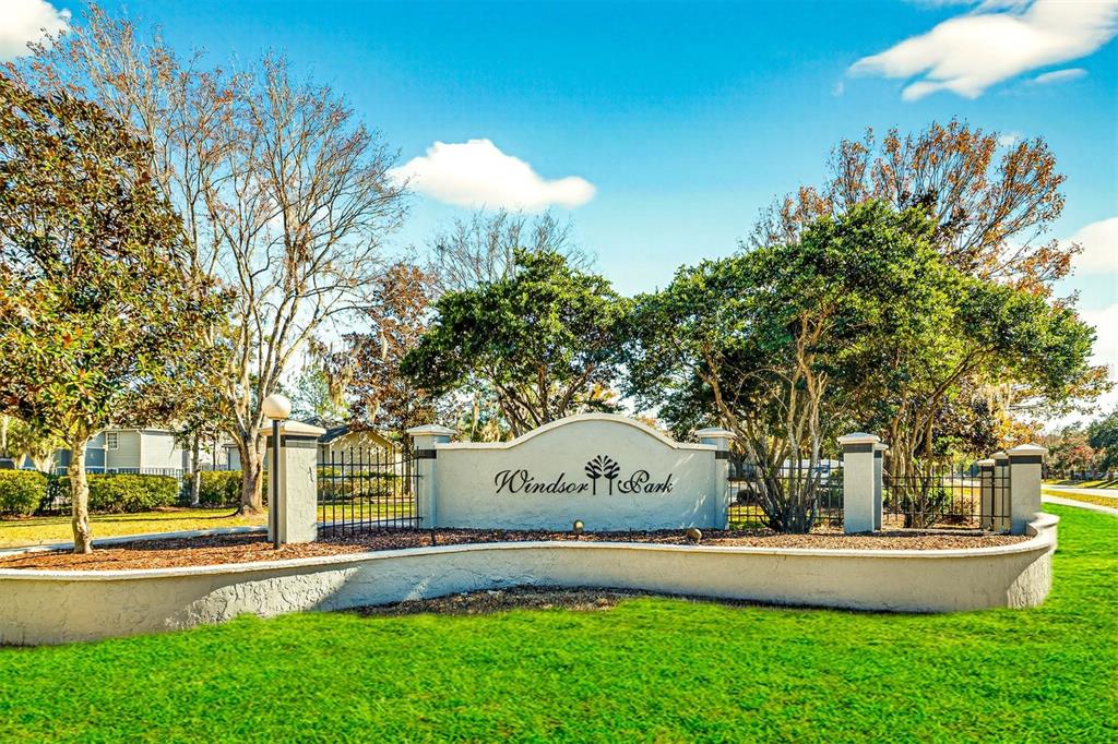 A curved stucco wall with the Windsor Park sign stands in a grassy landscaped area — 3705 SW 27TH STREET UNIT 326, GAINESVILLE, FL