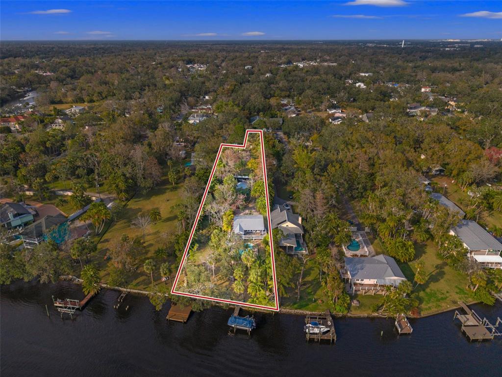 An aerial view shows a waterfront property outlined in red with a house and dock — 906 W HENRY AVENUE, TAMPA, FL
