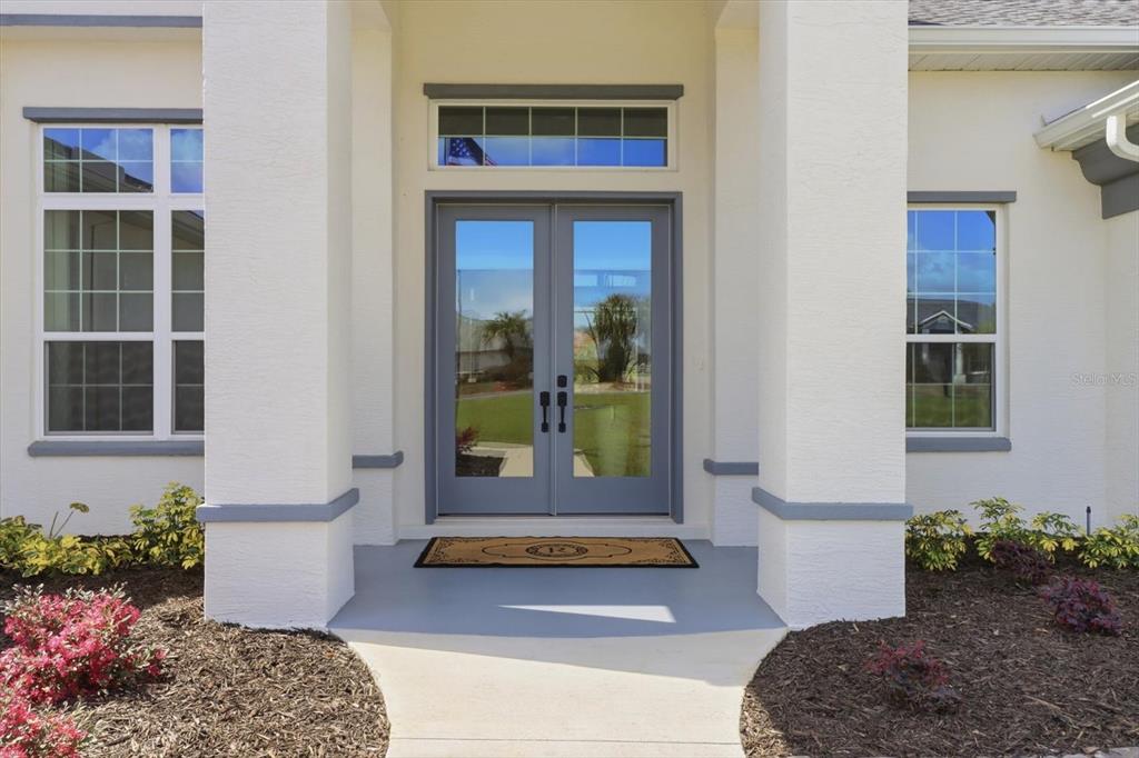 A front entryway features double glass doors, white columns, and a concrete walkway — 418 N CHERRY POP DRIVE, INVERNESS, FL