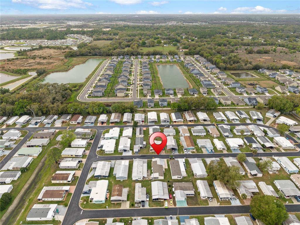 An aerial view shows a residential neighborhood with a red location pin on a house — 3120 POND HOLLOW STREET, WESLEY CHAPEL, FL