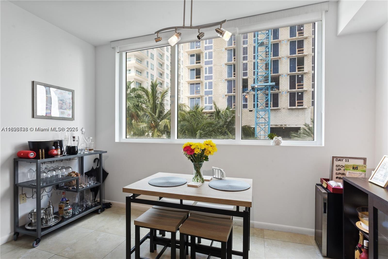 A dining area features a small table with stools, a bar cart, and large windows — 253 NE 2nd St # 1108, Miami FL 33132, MIAMI, FL
