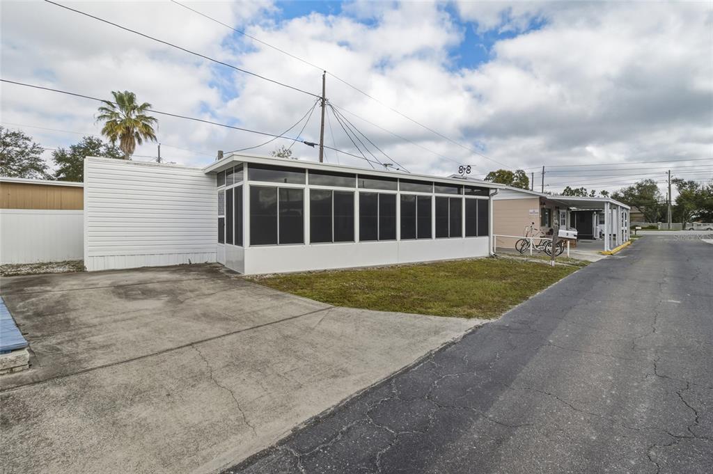 A mobile home with a white exterior and a large screened-in porch sits beside a driveway — 12766 SEMINOLE BOULEVARD UNIT 3, LARGO, FL