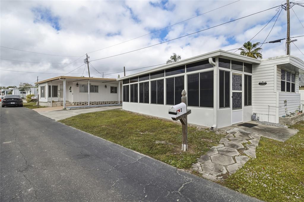 The exterior view shows a white manufactured home with a large enclosed sunroom and driveway — 12766 SEMINOLE BOULEVARD UNIT 3, LARGO, FL