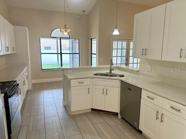 A kitchen features white cabinets, light countertops, stainless steel appliances, and tile flooring — 12686 NEWFIELD DRIVE, ORLANDO, FL