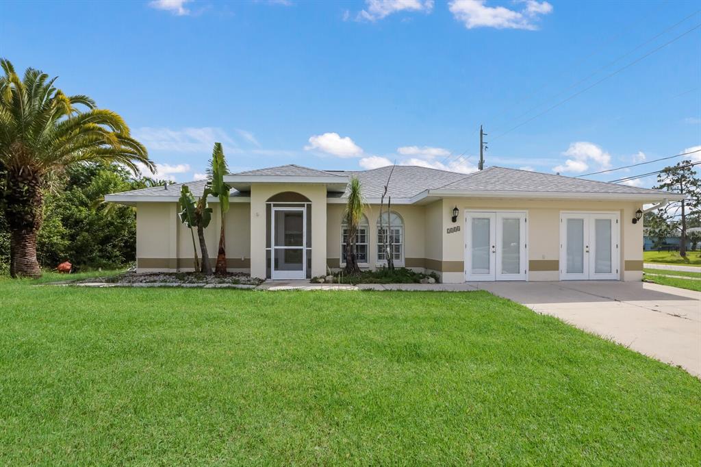 A single-story house with a light-colored exterior, a screen door, and a concrete driveway — 2004 BOCA CHICA AVENUE, NORTH PORT, FL