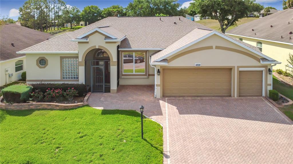 A single-story house with a brick paver driveway, a three-car garage, and a front entryway — 4810 SABLE RIDGE COURT, LEESBURG, FL