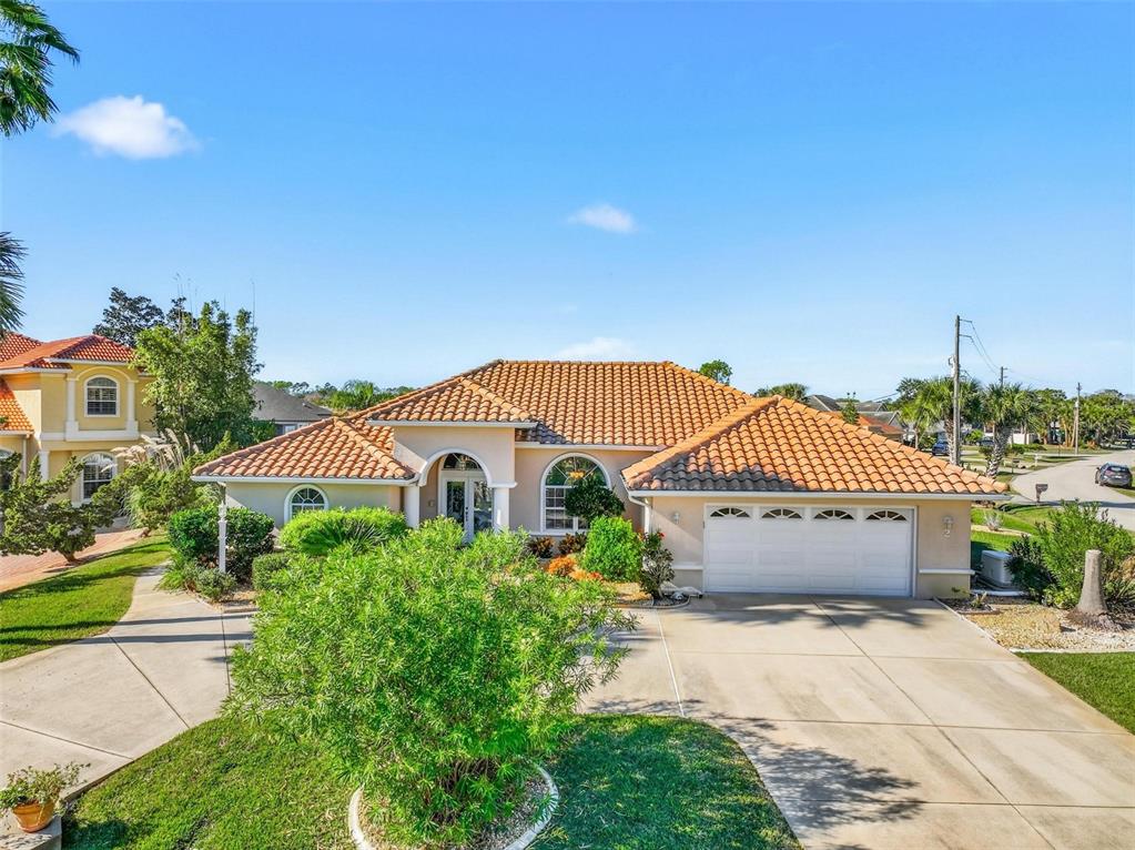 A single-story house with a terracotta tile roof and a two-car garage — 2 CHER COURT, PALM COAST, FL