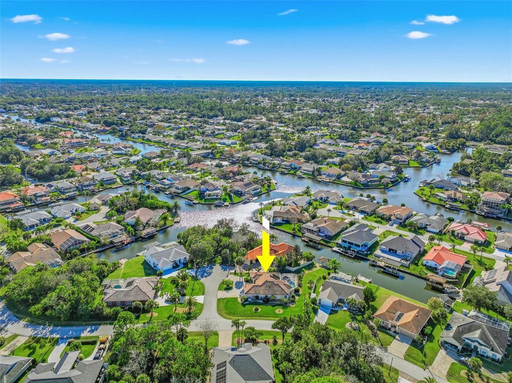 An aerial view shows a residential house with a pool located on a canal — 2 CHER COURT, PALM COAST, FL