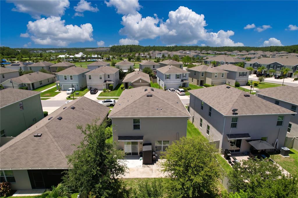 An aerial view shows the backyards and rear exteriors of several suburban houses — 16192 SILENT SANDS LANE, ODESSA, FL