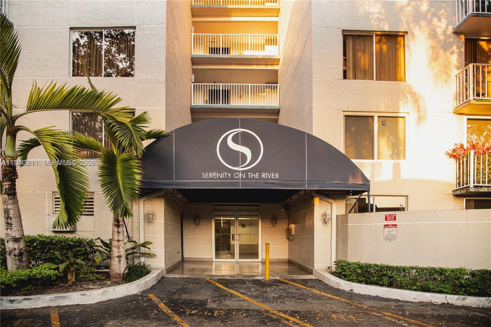 The exterior entrance of a multi-story apartment building features a dark awning with signage — 1740 NW N River Dr # 614, Miami FL 33125, MIAMI, FL