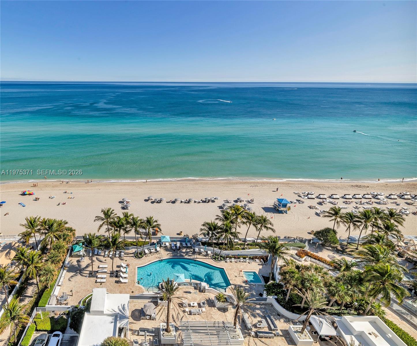 An aerial view shows a swimming pool and palm trees overlooking a sandy beach — 3535 S Ocean Dr # 1602, Hollywood FL 33019, HOLLYWOOD, FL