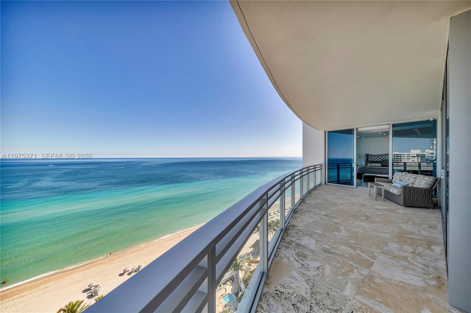A balcony with stone flooring overlooks the ocean and beach from a high-rise building — 3535 S Ocean Dr # 1602, Hollywood FL 33019, HOLLYWOOD, FL