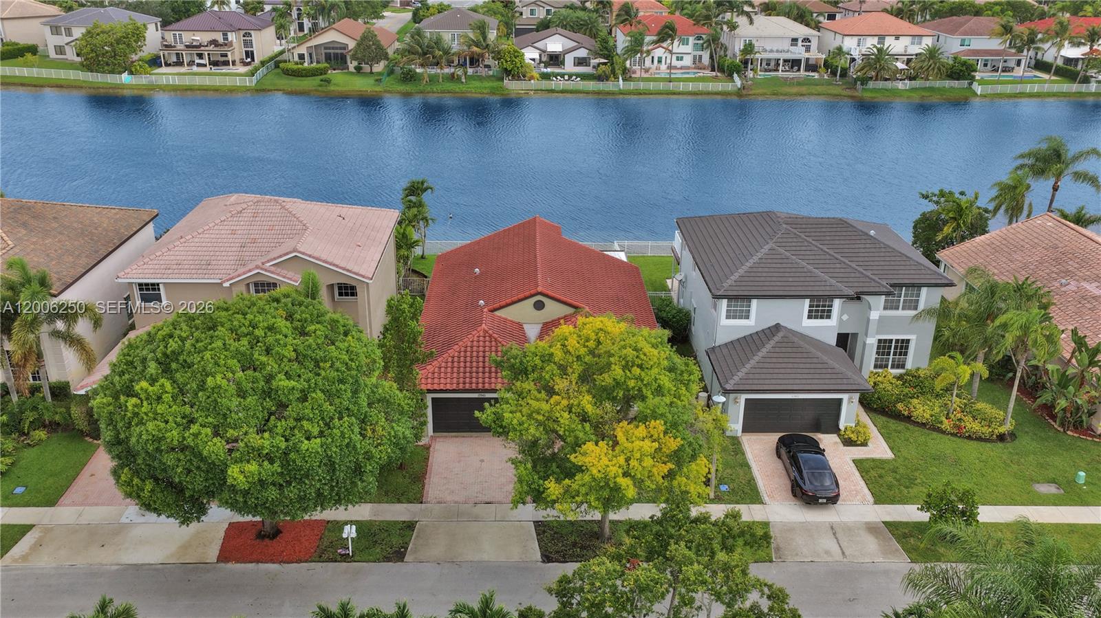 A kitchen features dark wood cabinets, stainless steel appliances, and light-colored stone countertops — 17961 SW 27th St, Miramar FL 33029, MIRAMAR, FL