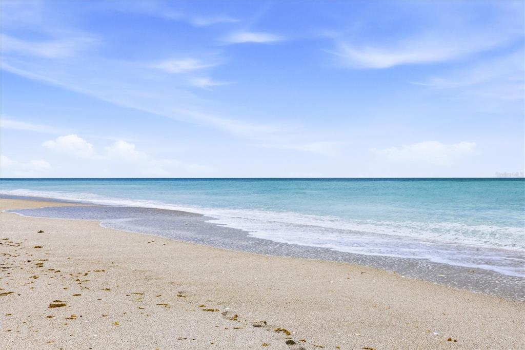 A view of a sandy beach meeting the turquoise ocean under a blue sky — 1210 SHORE VIEW DRIVE UNIT B, ENGLEWOOD, FL