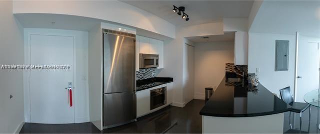 A modern kitchen features stainless steel appliances, white cabinetry, and a black granite breakfast bar — 92 SW 3rd St # 1802, Miami FL 33130, MIAMI, FL