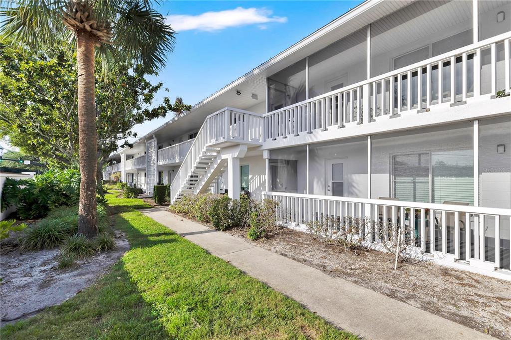 A two-story apartment building with white exterior walls, screened balconies, and an outdoor staircase — 1140 S ORLANDO AVENUE UNIT I14, MAITLAND, FL