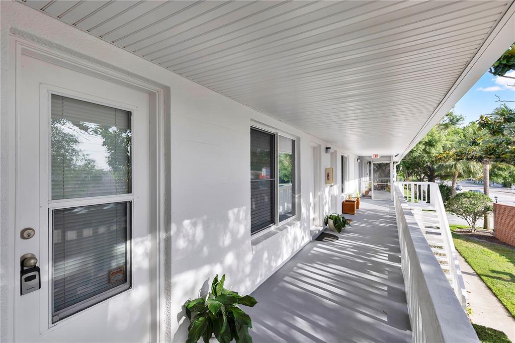 An exterior view of a white building with a covered walkway and a white railing — 1140 S ORLANDO AVENUE UNIT I14, MAITLAND, FL