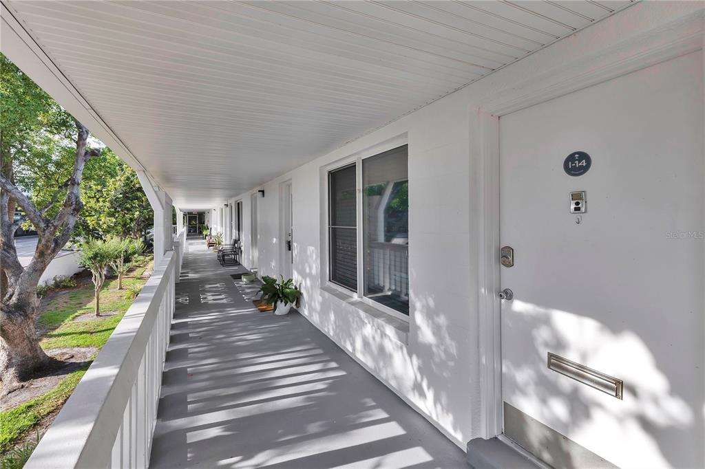 An outdoor covered walkway features a white door labeled 1-14 and a white railing — 1140 S ORLANDO AVENUE UNIT I14, MAITLAND, FL