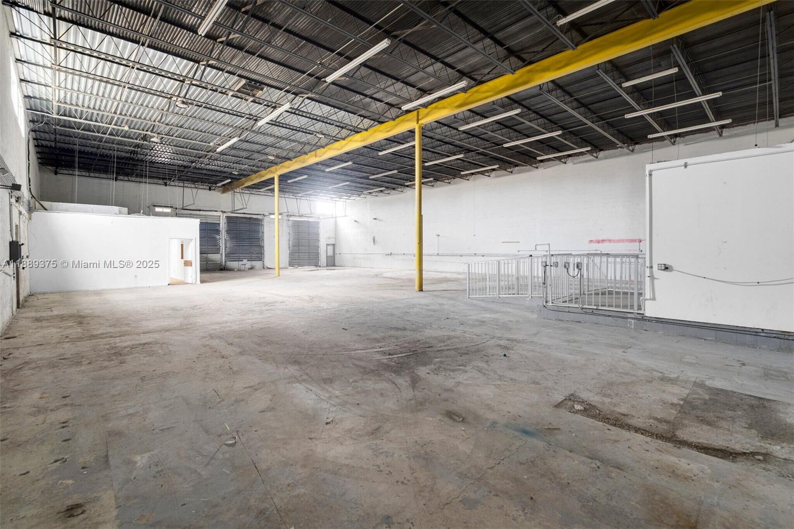 An expansive, empty industrial warehouse features a concrete floor, exposed ceiling, and yellow support beams — 4201 NW 37th Ct # 3725, Hialeah FL 33142, HIALEAH, FL