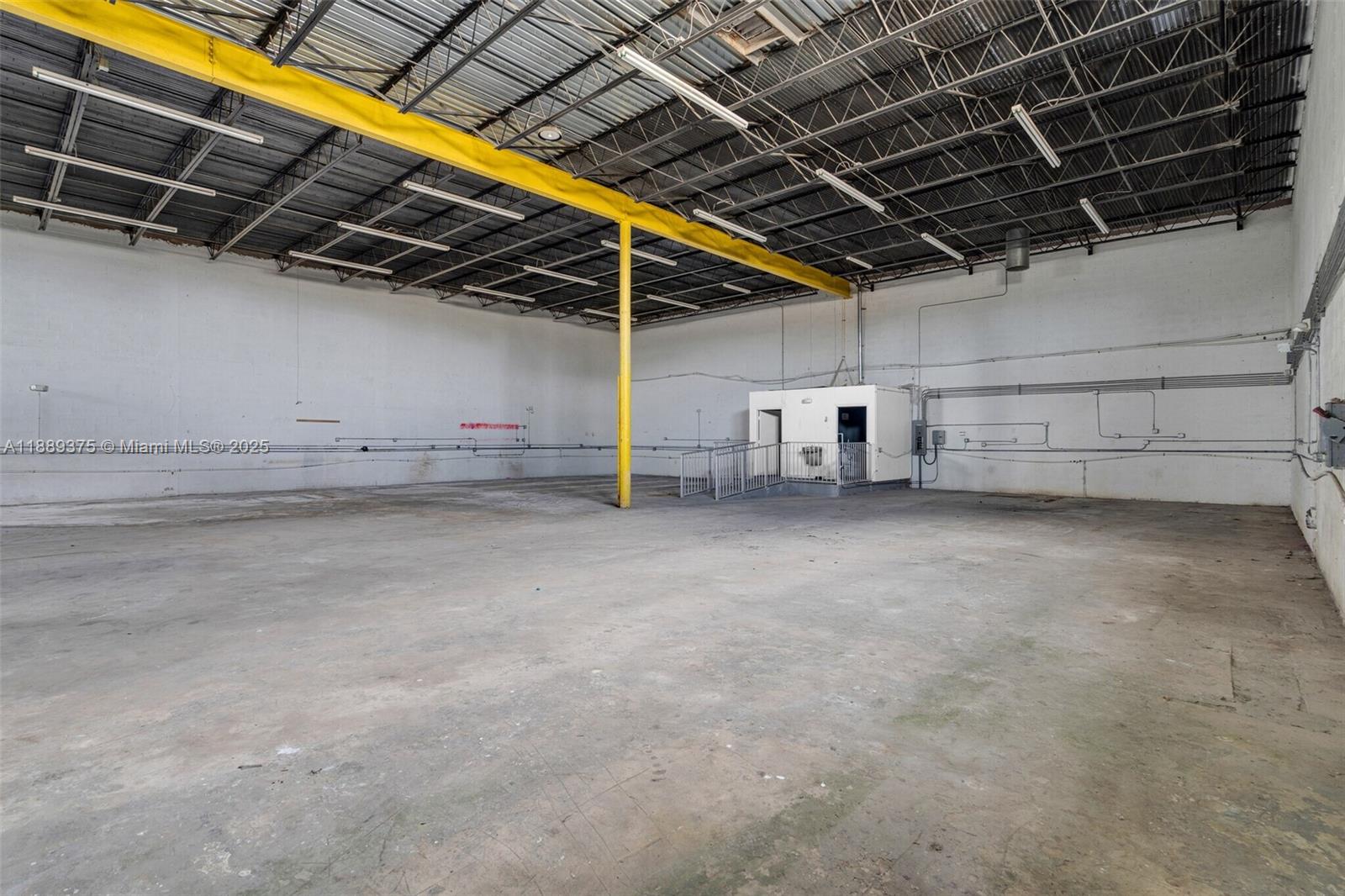 An empty industrial warehouse space features a concrete floor, white walls, and a yellow beam — 4201 NW 37th Ct # 3725, Hialeah FL 33142, HIALEAH, FL