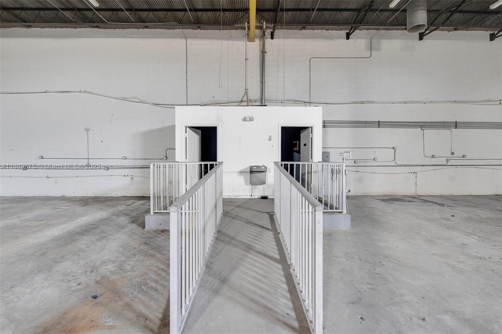 A concrete warehouse interior features a central elevated platform with two doorways and a fountain — 4201 NW 37th Ct # 3725, Hialeah FL 33142, HIALEAH, FL