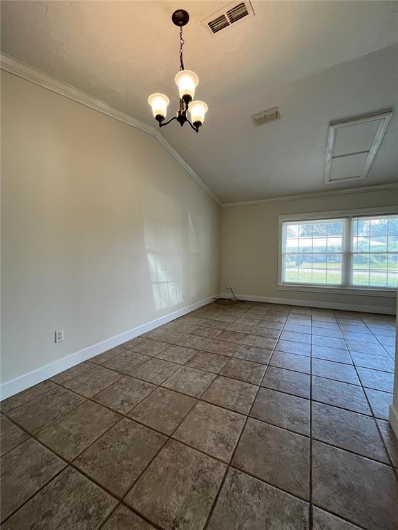An empty room with tan tile flooring, a vaulted ceiling, and a three-light chandelier — 3222 HAMMERSMITH ROAD, ORLANDO, FL