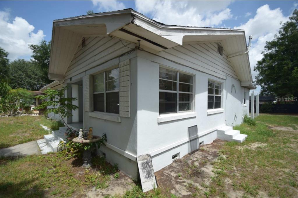 A white, single-story house with a gabled roof, wood siding, and a concrete foundation — 307 STEEDLY AVENUE, LAKE WALES, FL