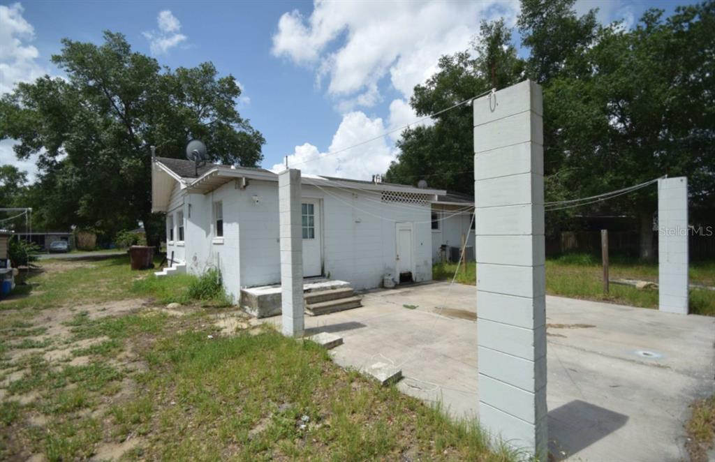 The exterior of a white house features a concrete patio with tall, free-standing block pillars — 307 STEEDLY AVENUE, LAKE WALES, FL