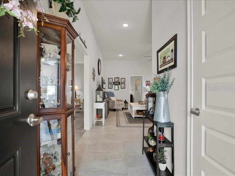 A view from an entryway into a home with tile floors and a display cabinet — 15648 SE 92ND AVENUE, SUMMERFIELD, FL