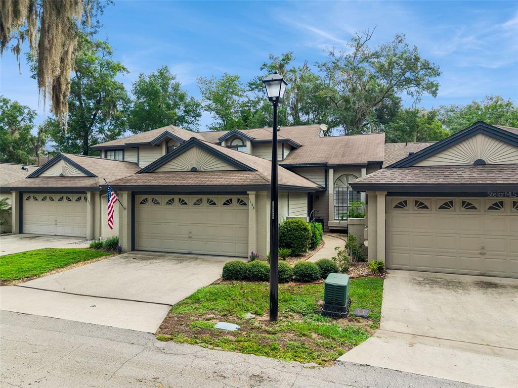 A multi-unit residential building with three garage doors and a central street lamp — 1123 BENT BIRCH COURT, ALTAMONTE SPRINGS, FL