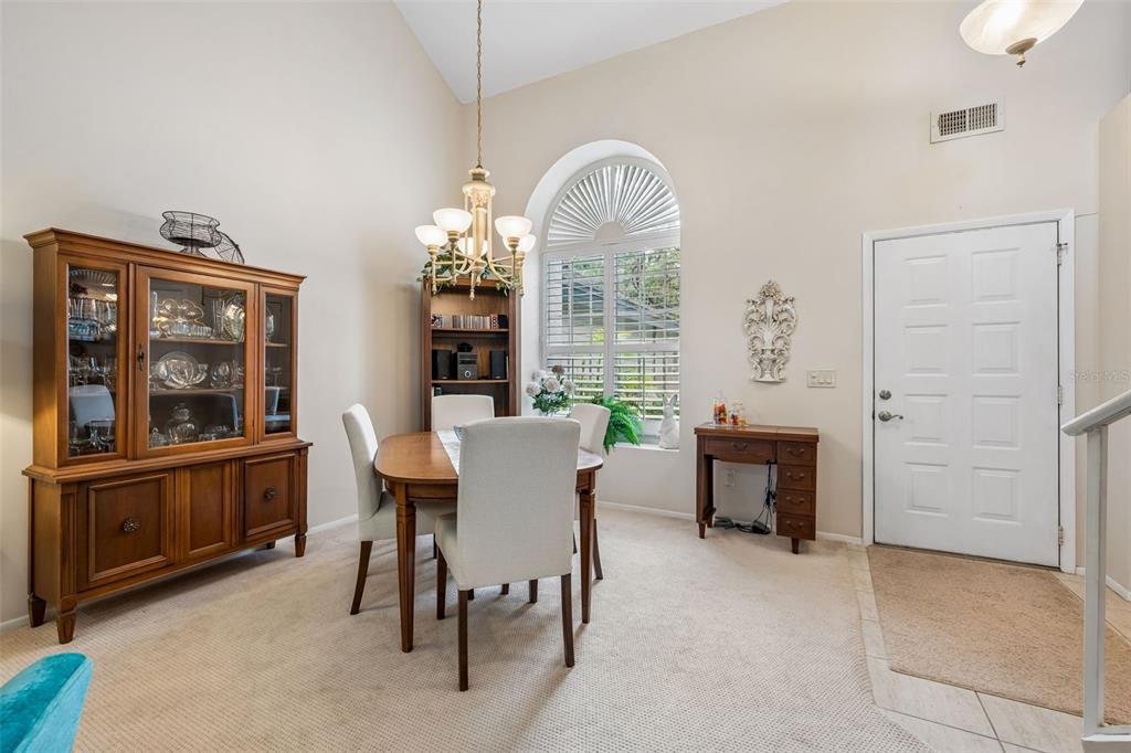 A dining room with a wooden hutch, round table, chairs, and an arched window — 1123 BENT BIRCH COURT, ALTAMONTE SPRINGS, FL