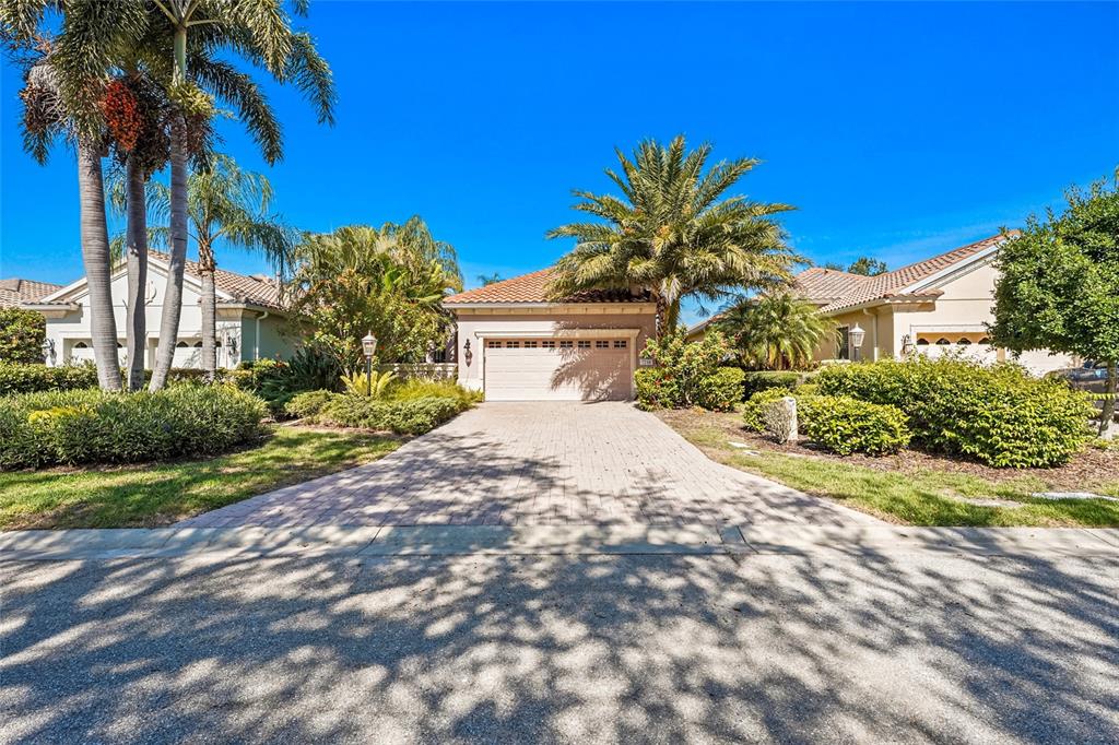 A single-story house with a paved driveway, a two-car garage, and palm trees — 7216 PRESIDIO GLEN, LAKEWOOD RANCH, FL