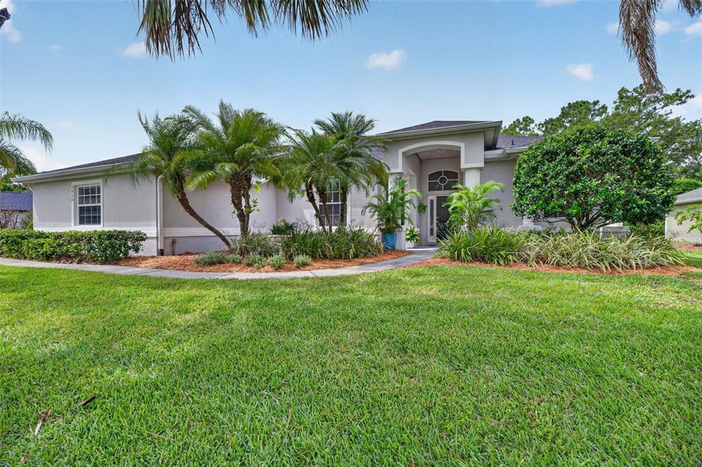 A single-story house with a light-colored exterior, palm trees, and a manicured lawn — 3650 MEADOWLARK WAY, MELBOURNE, FL