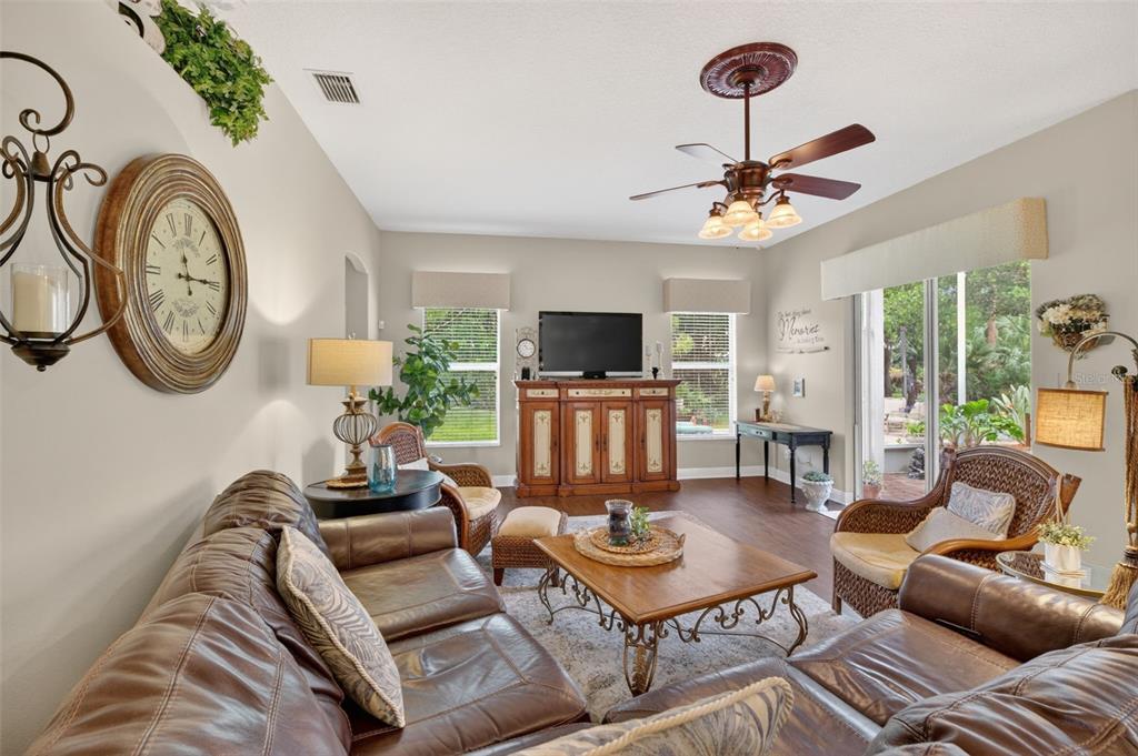A living room features leather sofas, a wooden coffee table, and a media console — 3650 MEADOWLARK WAY, MELBOURNE, FL