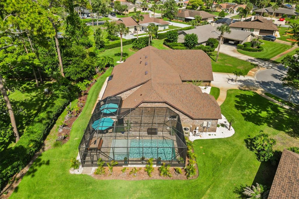 An aerial view of a house with a screened-in pool and a brown shingled roof — 112 PEACHTREE CIRCLE, DAYTONA BEACH, FL