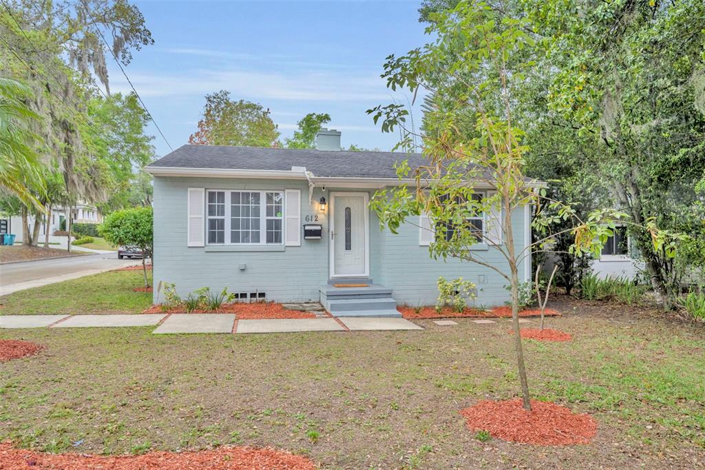 A light blue single-story brick house with white shutters and a front walkway — 612 E KALEY STREET, ORLANDO, FL