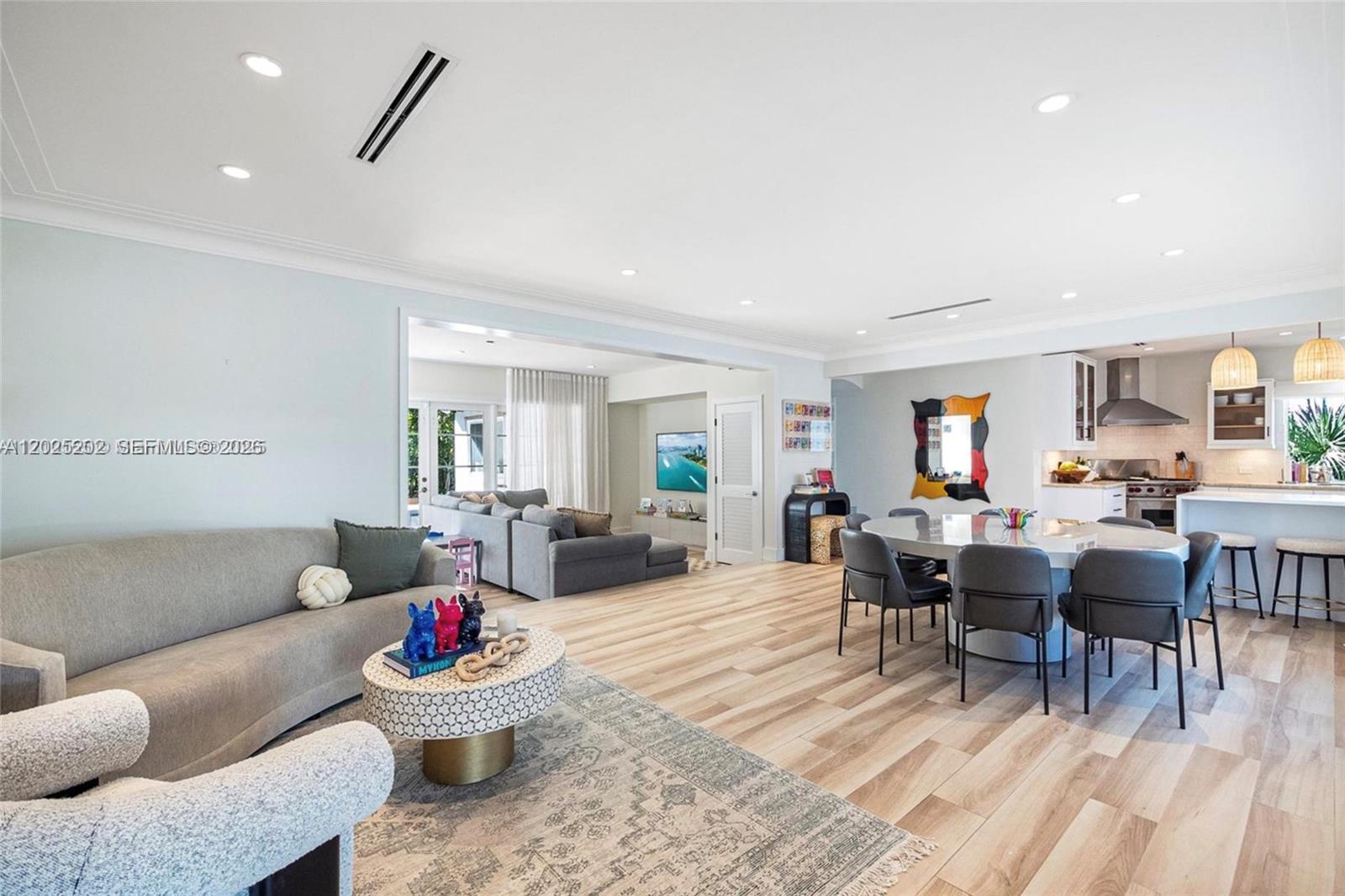 An open-concept living and dining area features light wood flooring and a modern kitchen — 1260 99th St, Bay Harbor Islands FL 33154, BAY HARBOR ISLANDS, FL