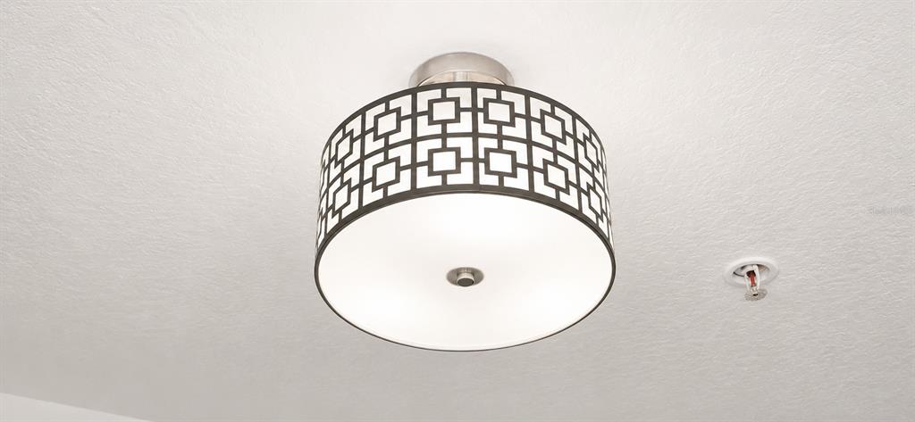 A drum-style ceiling light fixture with a geometric pattern is mounted on a white ceiling — 3326 ROBERT TRENT JONES DRIVE UNIT 209, ORLANDO, FL