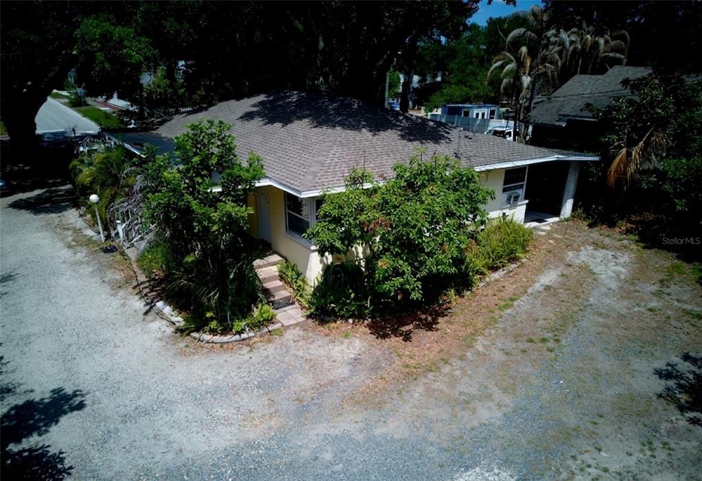 An aerial view of a single-story house with a gravel driveway and surrounding trees — 2119 S FERN CREEK AVENUE, ORLANDO, FL