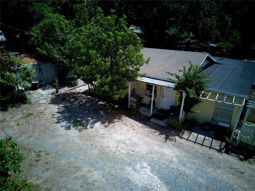 An aerial view shows a small, yellow house with a gravel yard and trees — 2119 S FERN CREEK AVENUE, ORLANDO, FL