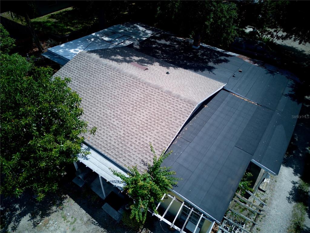 An aerial view shows the shingled and flat roofs of a house with surrounding trees — 2119 S FERN CREEK AVENUE, ORLANDO, FL