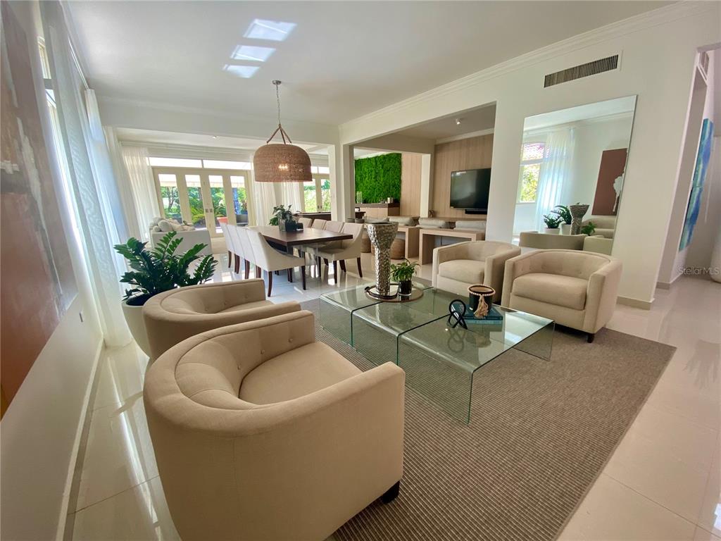A living room with beige armchairs, a glass coffee table, and an adjacent dining area — 13 DORADO BEACH EAST STREET, DORADO, PR