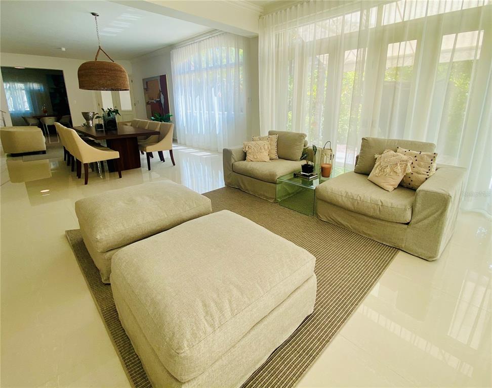 A living room and dining area feature light-colored furniture, tile floors, and floor-to-ceiling curtains — 13 DORADO BEACH EAST STREET, DORADO, PR