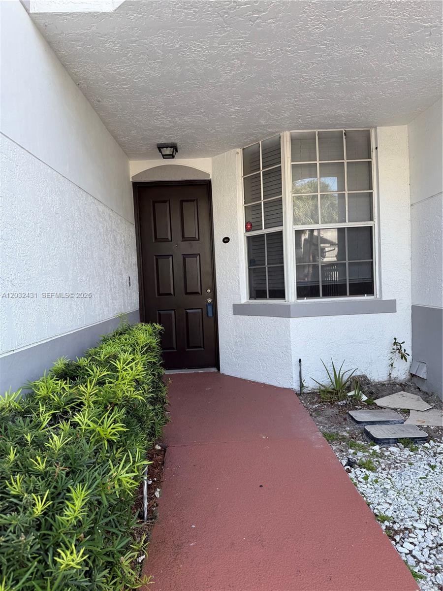 A brown front door is adjacent to a bay window on a covered entryway — 715 SW 148th Ave # 611, Sunrise FL 33325, SUNRISE, FL