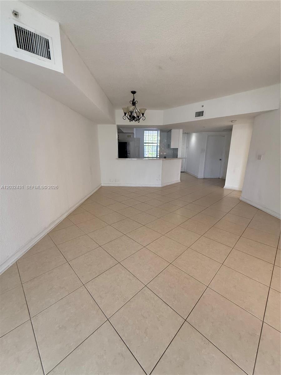 An open-concept living area features light-colored tile flooring and a kitchen with a breakfast bar — 715 SW 148th Ave # 611, Sunrise FL 33325, SUNRISE, FL